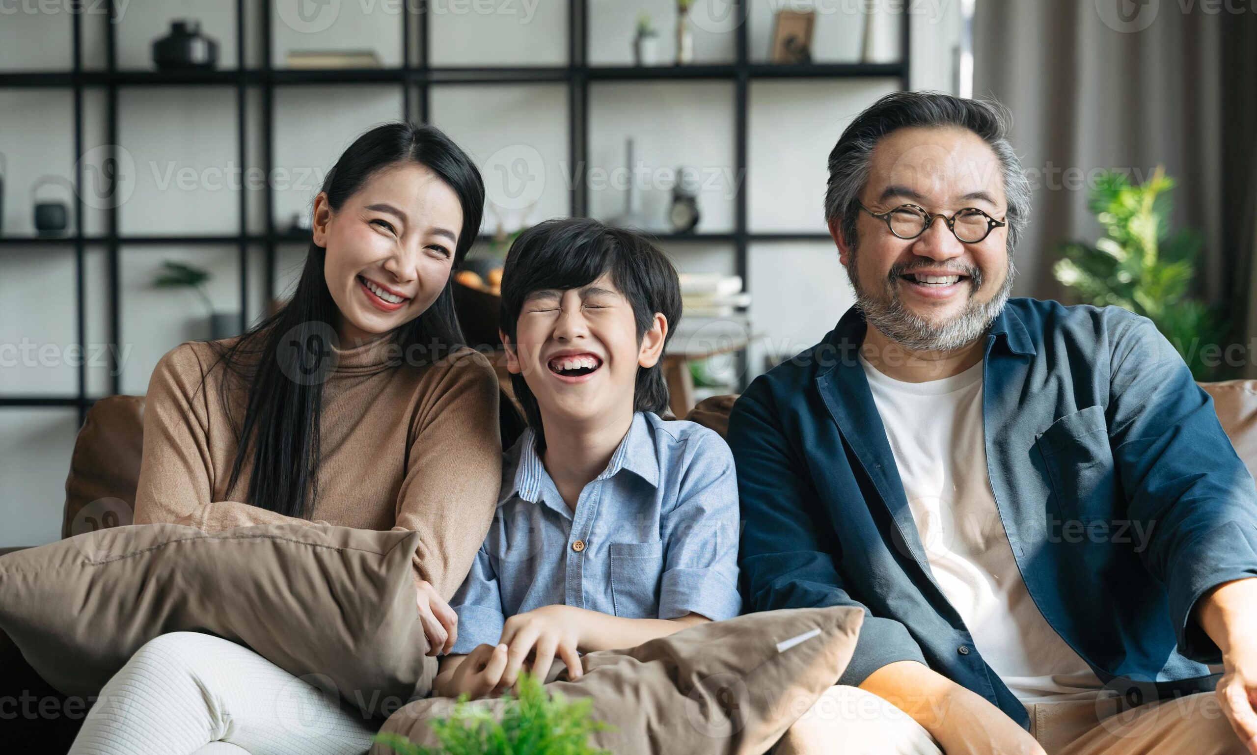 portrait-of-happy-asian-family-spending-time-together-on-sofa-in-living-room-family-and-home-concept-photo